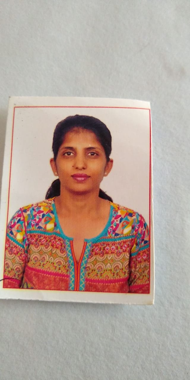 Portrait of Dr. Kapoor wearing traditional attire with academic books in background